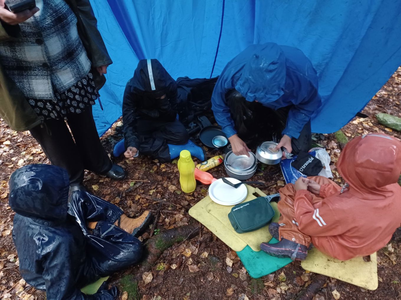 en gruppe mennesker som lager mat ute