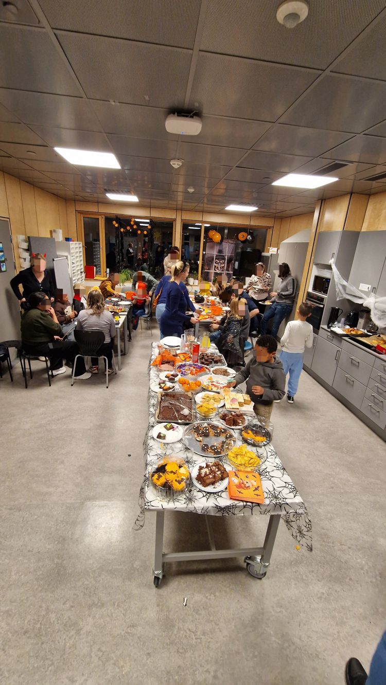 en gruppe mennesker i et rom med mat på et bord