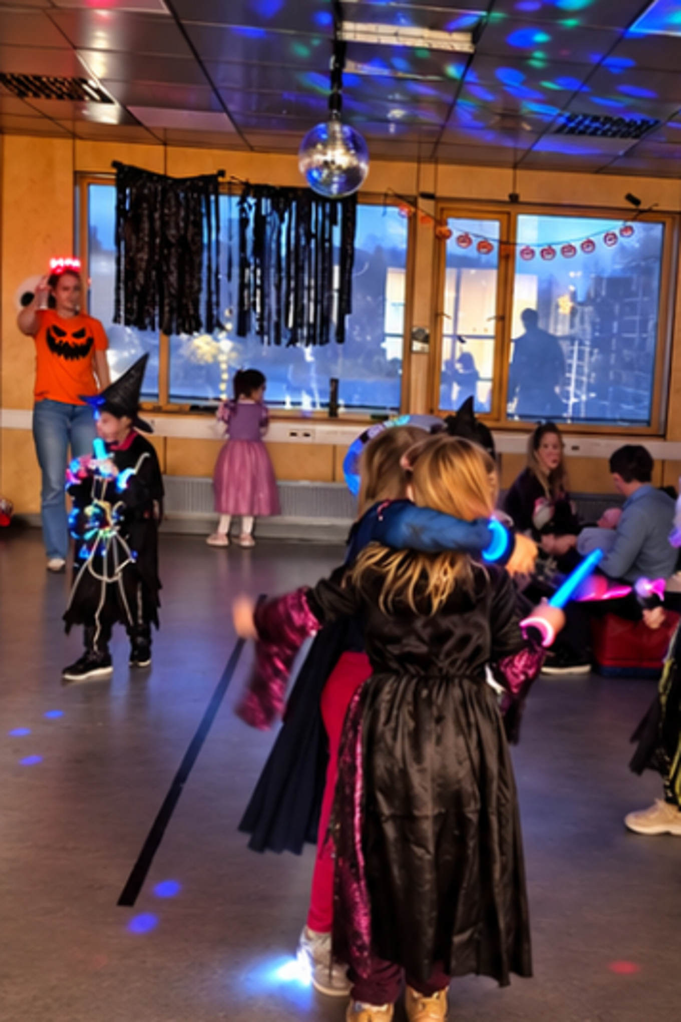en gruppe barn som danser i et rom med en person stående på en scene