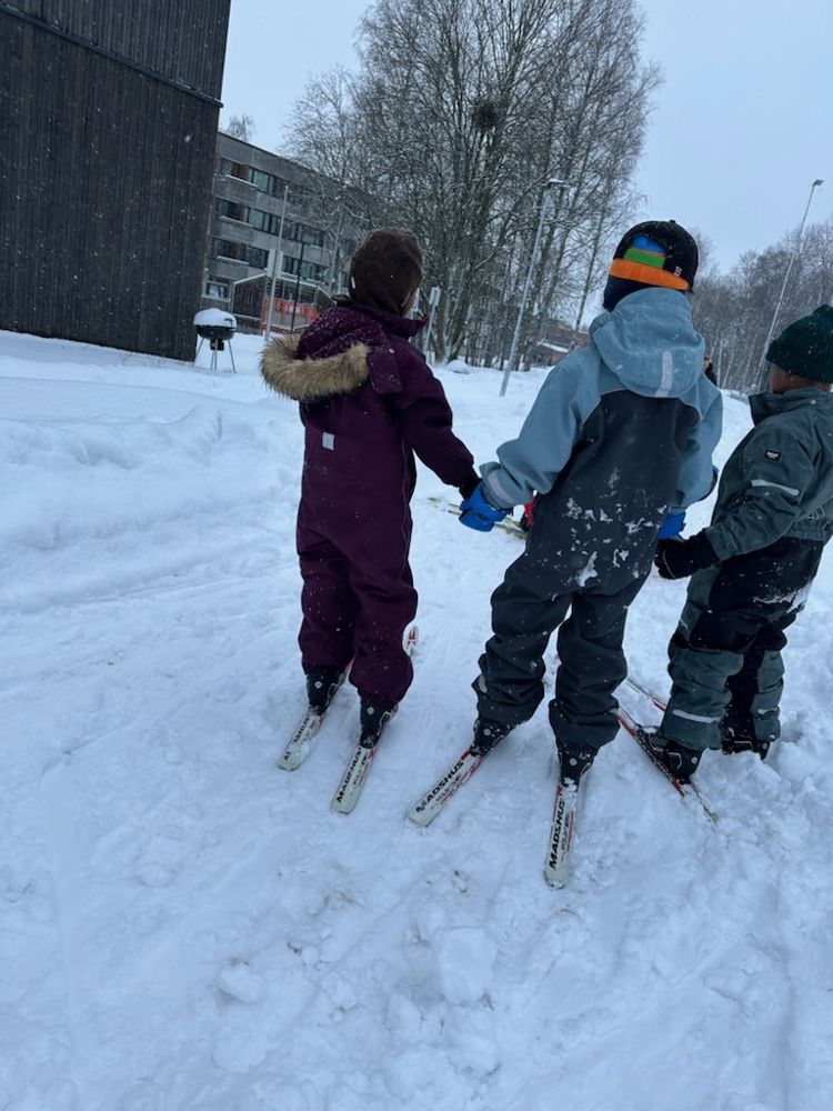 En gruppe mennesker står på snøski