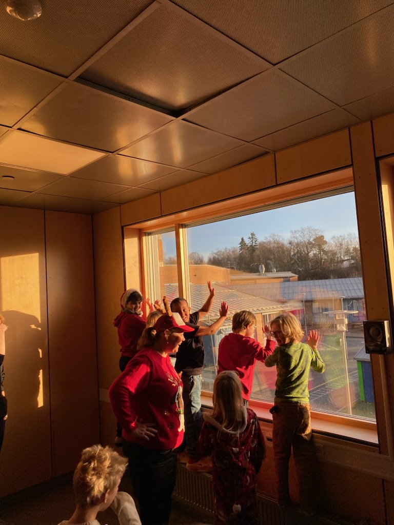 En gruppe barn som ser ut av et vindu