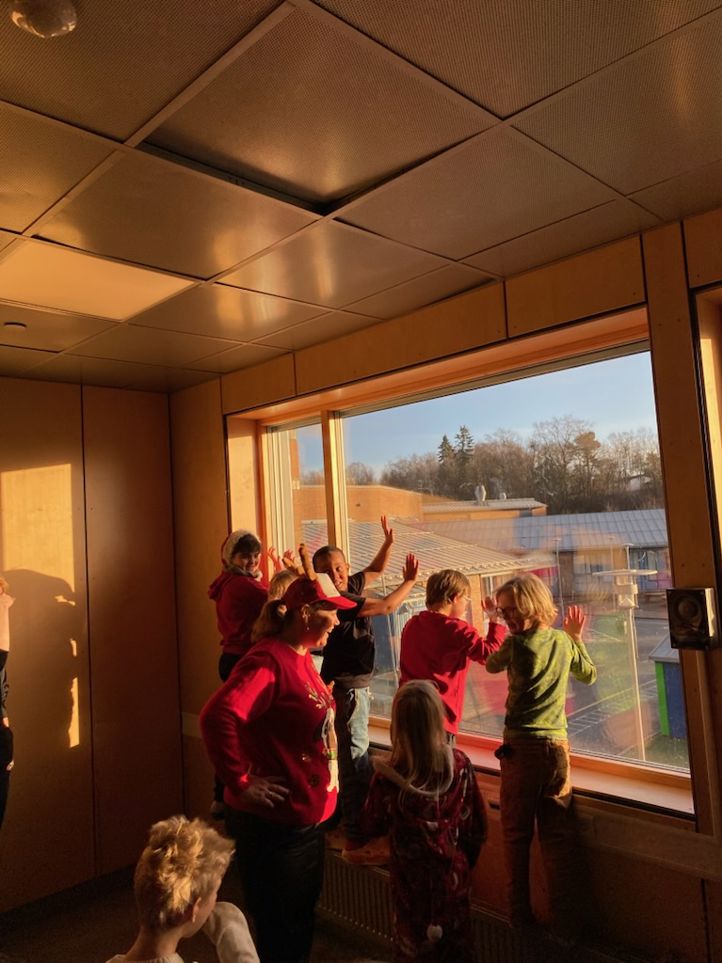 En gruppe barn som ser ut av et vindu