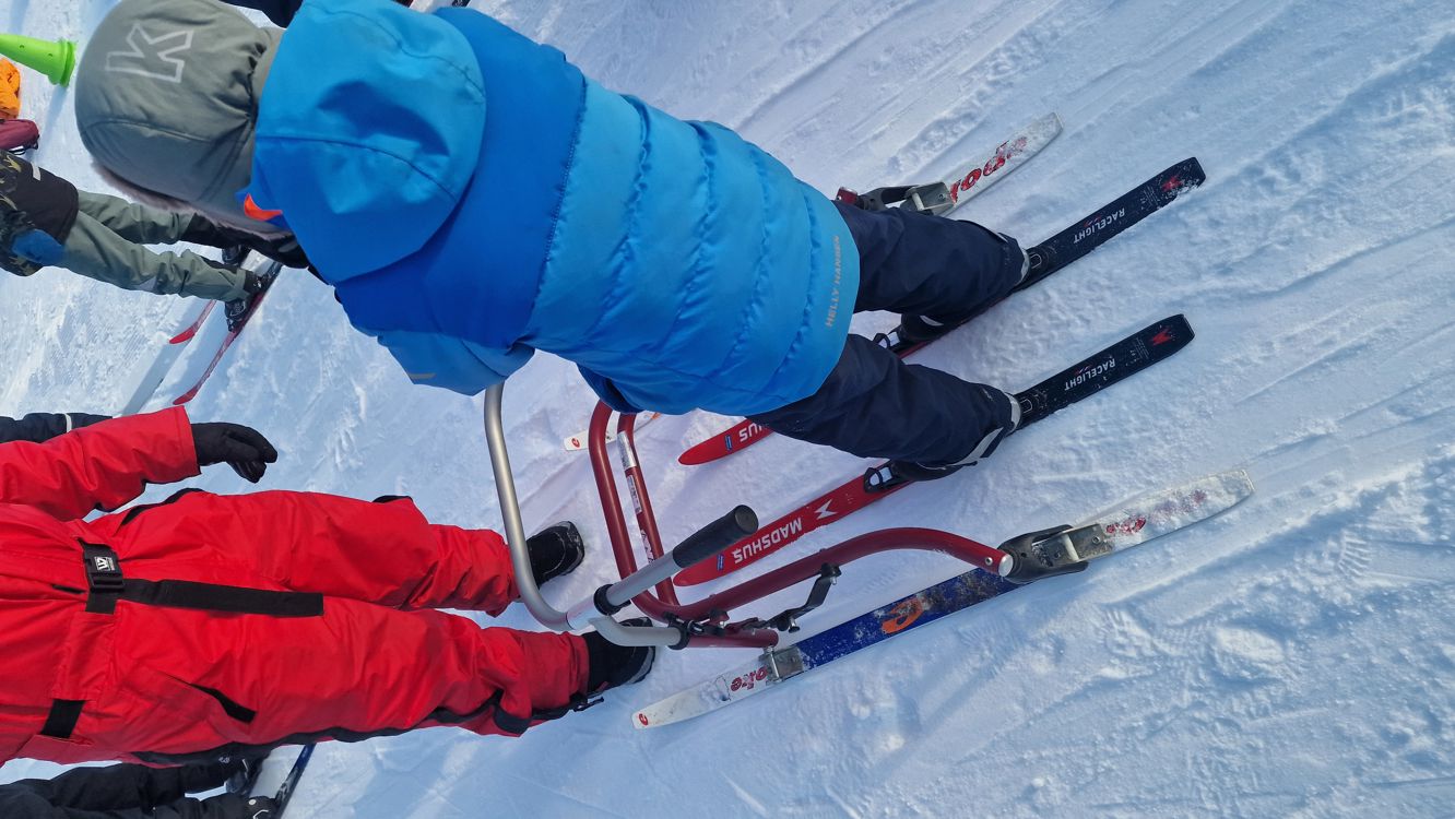 En gruppe mennesker står rundt noen ski